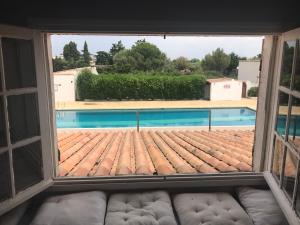 a window looking out at a swimming pool at Le Gite de Fanny in Saintes-Maries-de-la-Mer