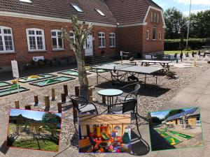 un cortile con tavoli, sedie e parco giochi di Hestkær Family Rooms a Grindsted