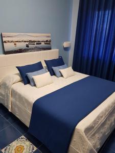un grande letto con cuscini blu e bianchi di BLU SEA SORRENTO a Sorrento