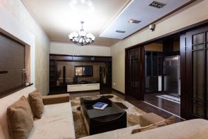 een woonkamer met een bank en een tv bij Efendi Apartment in Tasjkent