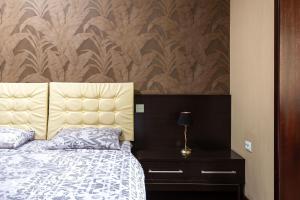 1 dormitorio con cama y pared con papel pintado en Efendi Apartment, en Tashkent