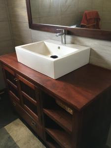 a white sink on a wooden counter with a mirror at Apries de Sais - villa de standing avec piscine in Aogan