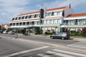 a car driving down a street next to a tall building at Hotel Suave Mar in Esposende