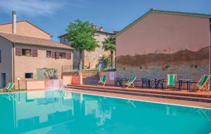 a swimming pool with tables and chairs next to a building at Borgo degli Orti in Montaione