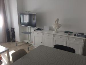 ein Wohnzimmer mit einem Tisch und einem TV an der Wand in der Unterkunft Málaga Habitación en Apartamento Carlos Haya in Málaga