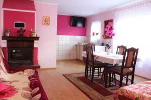 a dining room with a table and a room with a fireplace at Agroturystyka Zielona Polana in Wąglikowice