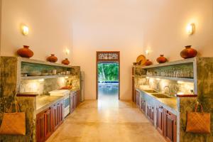 a large kitchen with wooden counters and vases on the shelves at Gangananda in Ambalangoda