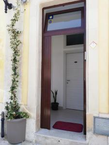 eine Tür mit einer roten Matte vor einem Gebäude in der Unterkunft Casa Andolina White in Noto