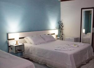 ペネドにあるPousada Doce Melのベッドルーム(大きな白いベッド1台、鏡付)