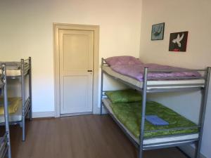 a room with three bunk beds and a door at Wein Lodge Durbach - Gruppenhaus Weingut Neveu in Durbach