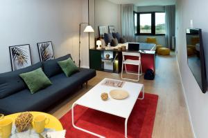 uma sala de estar com um sofá e uma mesa em The Oliver Apartamentos em Pozuelo de Alarcón