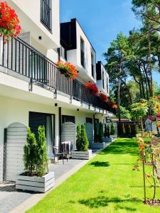 a building with a green lawn in front of it at Wojtecki Apartamenty in Pobierowo