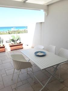 einen weißen Tisch und Stühle in einem Zimmer mit Meerblick in der Unterkunft DueAttici e un Pianoterra in Gallipoli
