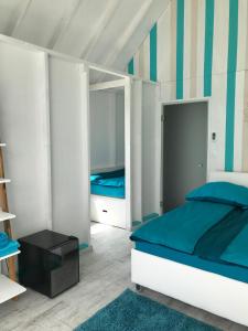 a bedroom with a bed with blue and white stripes at LupaGlamping in Budakalász