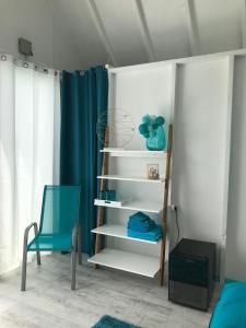 um quarto com uma estante de livros e uma cadeira azul em LupaGlamping em Budakalász
