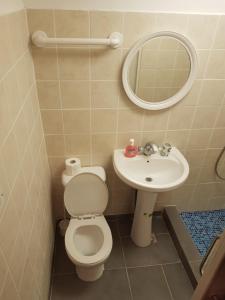 uma casa de banho com um WC, um lavatório e um espelho. em Trianon em Pafos