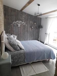 1 dormitorio con 1 cama grande y cabecero de madera en l' Oiseau Bleu, en Bazoges-en-Pareds