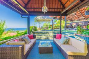 Un patio al aire libre con sofás y una mesa. en Vista Ballena, en Uvita