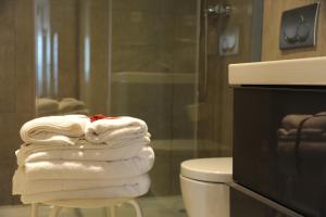 a stack of towels sitting on a stool in a bathroom at Capim Dourado Apartments Cedofeita in Porto +31 photos