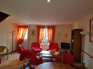 a living room with red chairs and a table at La Croix de la Jarrie in Châtres