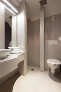 a white bathroom with a sink and a toilet at Hotel Boterhuis in Bruges