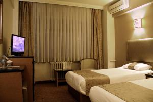 a hotel room with two beds and a television at Hotel Artiç in Bursa