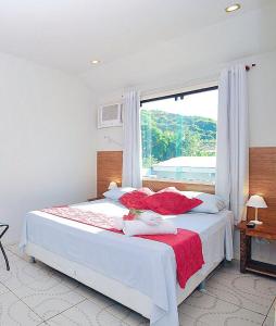een slaapkamer met een groot bed en een groot raam bij Pousada Brisas de Búzios in Búzios