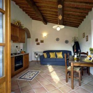Una sala de estar con un sofá azul y una mesa. en Casa Elisa, en Montaione