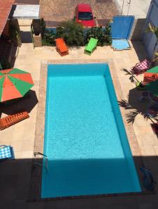 - une vue sur la piscine bleue et ses parasols dans l'établissement POUSADA MARINA PRAiA, à Beberibe