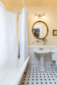 a bathroom with a sink and a toilet and a mirror at Cedar Crest Inn in Asheville