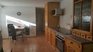 a kitchen with a sink and a table with chairs at Ferienwohnung Rixen in Dargelin