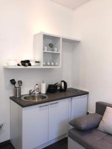 una piccola cucina con lavandino e divano di Antwerp appartments a Sarajevo