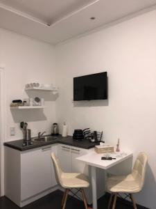 cocina con mesa y sillas y TV en la pared en Antwerp apartments, en Sarajevo
