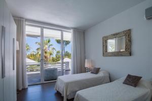 a hotel room with two beds and a balcony at Can Love in Cala Comte +46 photos