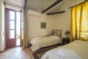 a bedroom with two beds and a sliding glass door at Vilelmine in Chania Town