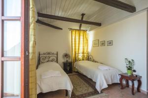 1 dormitorio con 2 camas y ventana en Vilelmine, en La Canea