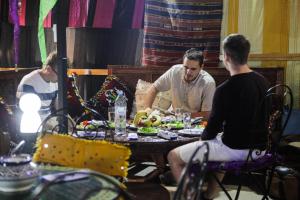 un grupo de hombres sentados en una mesa comiendo comida en Dar Berrada - Ziat en Fez