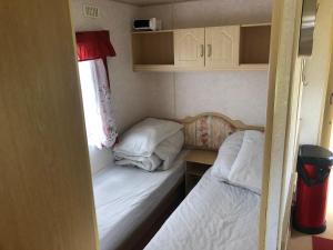 a small room with two beds and a window at i15 The Chase in Ingoldmells