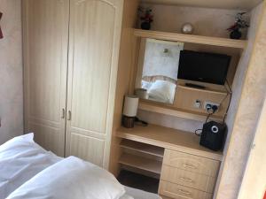 a bedroom with a bed and a desk with a television at i15 The Chase in Ingoldmells