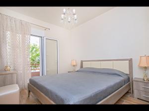 a bedroom with a bed and a chandelier at Pasithea House in Skala Sotiros