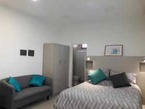 um quarto com uma cama e um sofá em Apart Camilo em Mendoza
