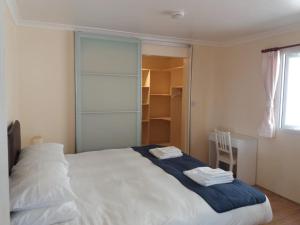 Un dormitorio con una cama blanca con una manta azul. en Summit View en Jamestown
