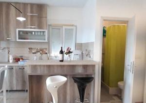 a kitchen with a sink and a counter with a stool at Apartment Iva in Bijela