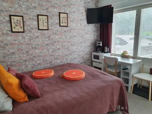 a bedroom with a bed with two orange plates on it at Hamina Orange Apartments Loft in Hamina
