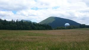 a large field with a mountain in the background at SEJOUR AU COEUR DES VOLCANS in Saint-Ours