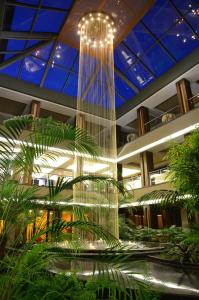 a large glass chandelier in a building with plants at Spa Hotel Calista in Starozagorski Bani