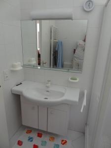 Baño blanco con lavabo y espejo en Casa Abel, en Campione dʼItalia