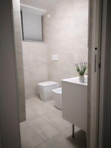 a white bathroom with a toilet and a sink at BGY Central Apartments in Bergamo