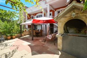 a patio with an umbrella and an outdoor oven at Apartments Petra in Marina