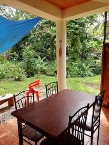 een houten tafel en stoelen op een veranda bij Caribbean Secret in Cahuita